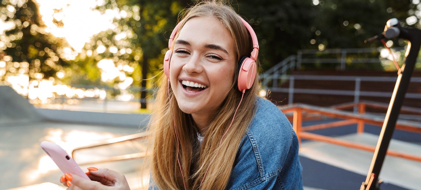 a smiling high schooler with headphones on