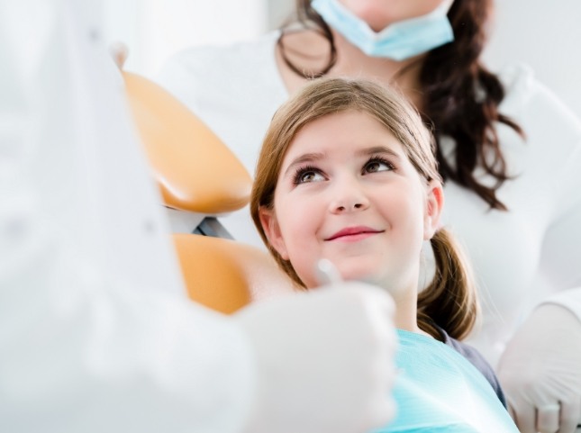 Young girl smiling at her dentist during a dental checkup