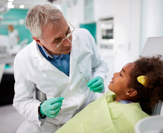 child smiling while visiting dentist 